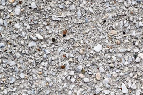 The surface of the concrete wall is covered with different stones. Stock Photos