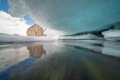 A surface covered with a thick layer of cracked ice. Stock Photos