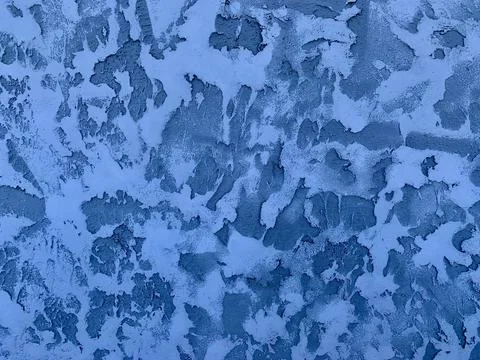 The surface displays intricate patterns formed by frozen blue paint, reminiscent Foto stock