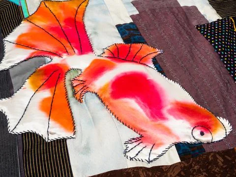 Surface of embroidered patchwork with goldfish Stock Photos