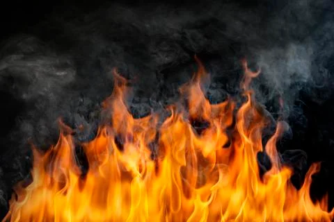 The surface of the fire and the burning smoke are hot on a black background. Stock Photos