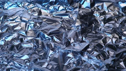 The surface of the foil is wrinkled. There is a blue light reflecting light.. Stock Footage 228953972