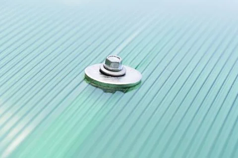 Surface of green Polycarbonate plastic sheet panel with Mounting Steel hex bo Stock Photos