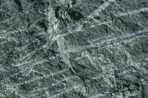 Surface grey granite stone with light lines and streaks. Stock Photos