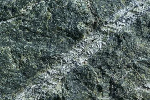Surface grey granite stone with light lines and streaks. Stock Photos