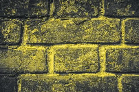 Surface of grunge brick wall painted in trendy yellow color of the year 2021 Stock Photos