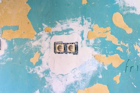 Surface grunge texture of power outlet in damaged cracked plastered paint wal Stock Photos
