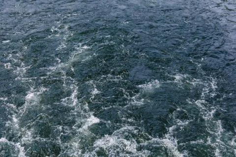 Surface of the lake or river behind the moving ship Stock Photos