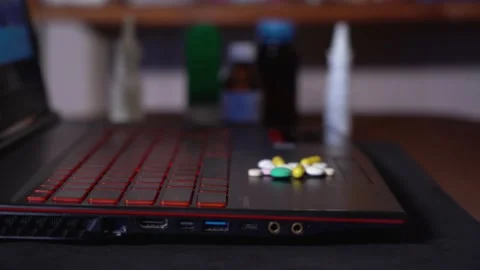 On the surface of the laptop move colored tablets in a pile. blurred background Stock-Footage 130198967