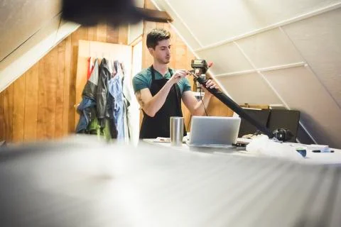 Surface level view of young man in workshop crafting object with tool Stock Photos