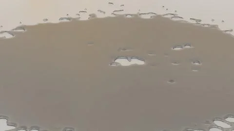 Surface of a liquid with translucent patches forming natural shapes on a ne.. Stock Photos