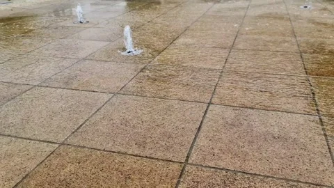 Surface of moving water on stone tiles reflecting sunlight in a fountain found Stock Footage 348322007
