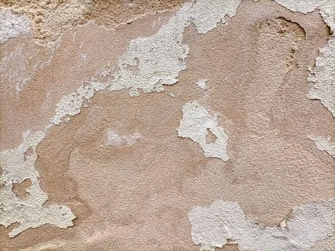 The surface of an old dilapidated wall with peeling off plaster in beige and Stock Photos