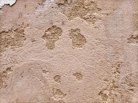 The surface of an old dilapidated wall with peeling off plaster in beige and Stock Photos