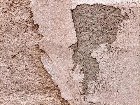 The surface of an old dilapidated wall with peeling off plaster in beige and Stock Photos