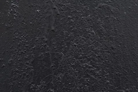 The surface of the old wall is painted with black oil paint. Stock Photos
