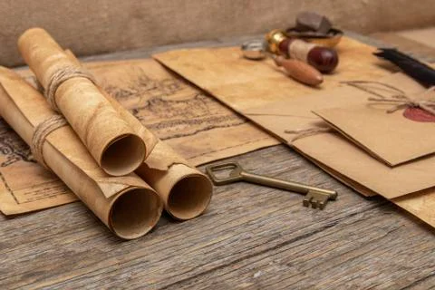 The surface of the old wooden table. On the table are old scrolls, an old map Stockfoto's