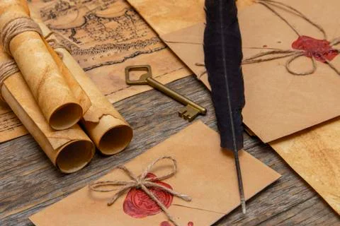 The surface of the old wooden table. On the table are old scrolls, an old map Stockfoto's