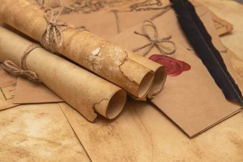 The surface of the old wooden table. On the table are old scrolls, an old map Stockfoto's