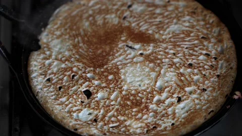 The surface of a pancake that is being fried in a pan. Stock Footage 170226293