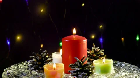 On a surface with a pattern, a large candle surrounded by pine cones Stock Footage 165049517