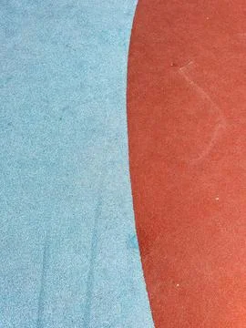Surface of a playground showing red and blue sections in a sunny location Stock Photos