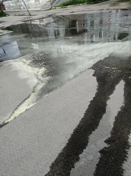 On the surface of the puddle after acidic sulfur rain visible streaks of sulf Stock Photos