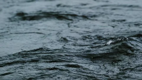 Surface of river or lake with raindrops disturbing water Stock Footage 335809960