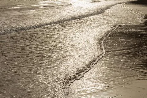 Surface of a sandy beach in Cyprus at evening light. Calm gentle surf with so Stock Photos