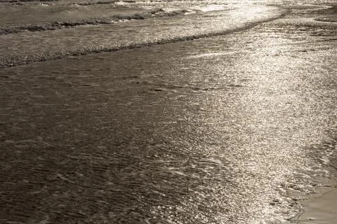 Surface of a sandy beach in Cyprus at evening light. Calm gentle surf with so Foto stock