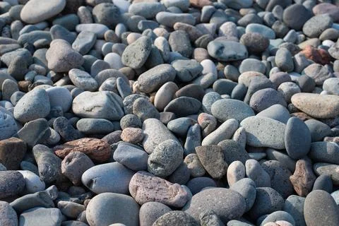 Surface of smooth rounded pebbles and small rocks, outdoor texture Stockfoto's