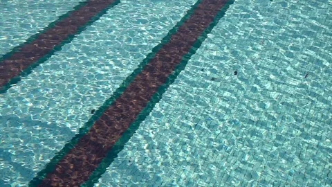 Surface of a swimming pool with sunlights on it, producing abstract patterns. Stock Footage 117445356