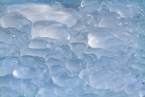 The surface of the transparent ice is covered with shiny bumps Stock Photos