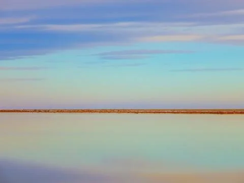 The surface of a vast reservoir with the reflection of clouds on a calm surfa Stock Photos