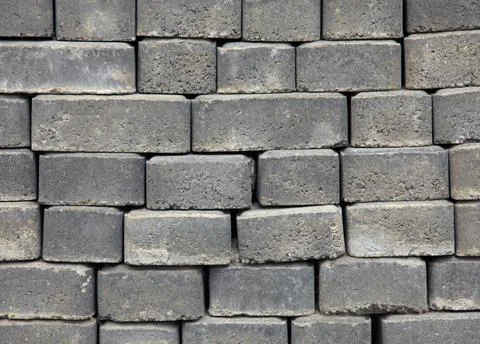 The surface of a wall or fence lined with gray bricks. Paving slabs Stock Photos