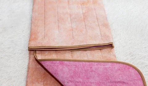 Surface of a warm two-sided pink and beige electro sheet, laid out on bed, .. Stock Photos