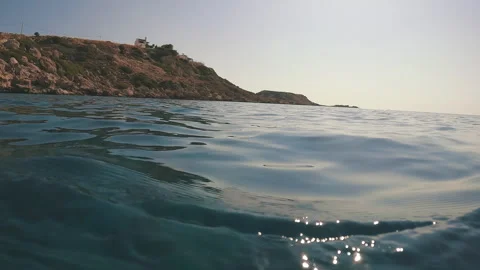 Surface of water with coastal rocks, Low-angle shot, backlight, seascape Stock Footage 255505446