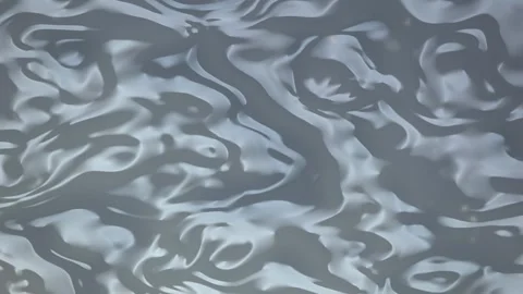 The surface of water moves gently creating undulating ripples and subtle spe Stock Footage 340678373