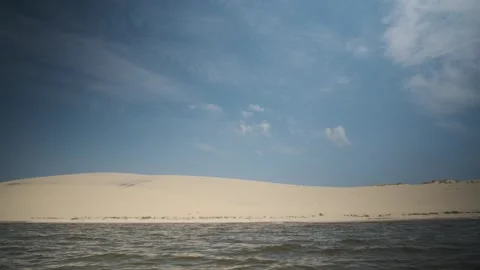 Surface of water with small waves on background of dunes in desert. Stock Footage 244604060