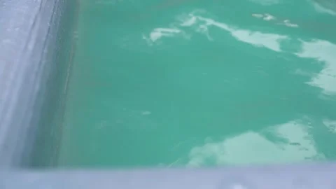 The surface of the water with waves in the pool is moving. Ripples with light Stock Footage 281678932