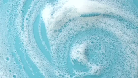 Surface with white soap foam on blue background, texture of foam with bubbles Stock Footage 232489751