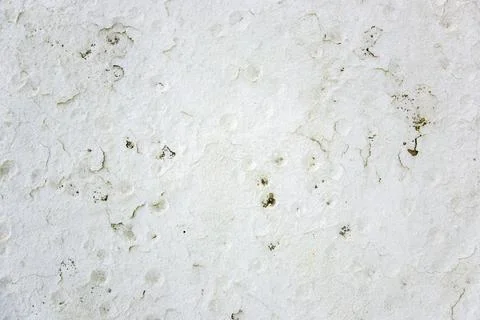 Surface of a white wall shows texture and marks from weather and time with spots Foto stock