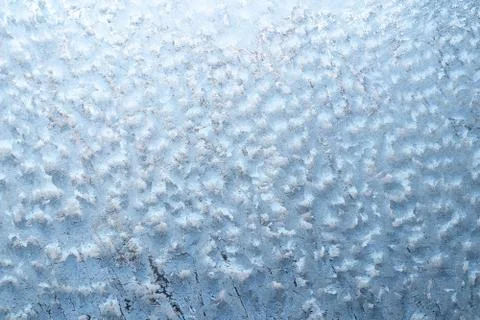 Surface of a winter frozen window is backlit by the sun outside, background,  Stock Photos