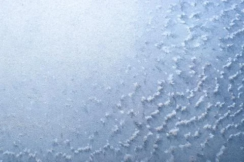 Surface of a winter frozen window is backlit by the sun outside, background,  Stock Photos