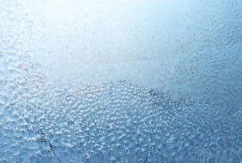 Surface of a winter frozen window is backlit by the sun outside, background,  Stock Photos