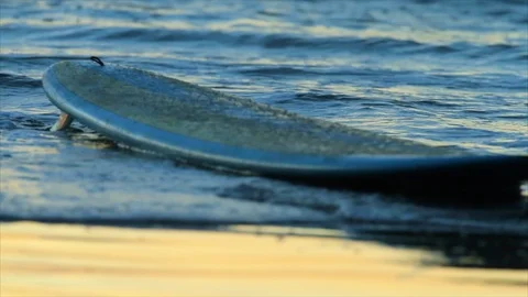 Surfboard being washed ashore. Stock Footage 88406163