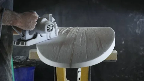 Surfboard making, Shaper using a foam sander tool on the bottom of the surfboard Stock Footage 131800287