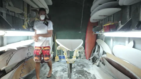 Surfboard shaping, Shaper using blower to blow the foam of the surfboard blank Video stock 64411554