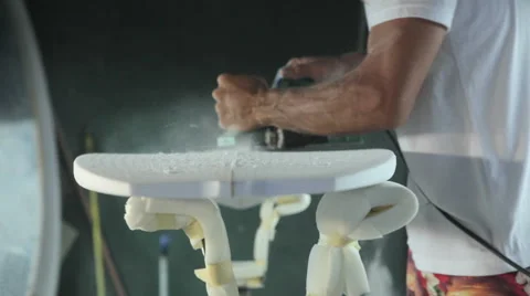 Surfboard shaping, Shaper using a tool to blow the foam of the surfboard blank Stock Footage 64410464