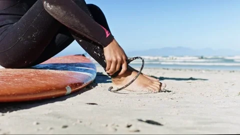 Surfer attaching leash before surfing Video stock 76521116